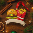 Load image into Gallery viewer, Decorative ornament shaped like a hamburger and fries on a wooden surface with Christmas decorations.