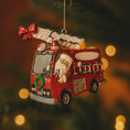 Load image into Gallery viewer, Christmas ornament of a red fire truck with Santa driving, hanging on a tree.