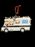 Load image into Gallery viewer, Decorative Christmas ornament of a family in a camper van with lights on a black background.