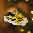 Load image into Gallery viewer, Christmas ornament of a snowmobile hanging on a tree with blurred lights in the background