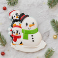Load image into Gallery viewer, Decorative snowman and penguins ornament on a marble surface with Christmas decorations.