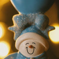 Load image into Gallery viewer, Decorative snowman figurine with a smiling face against a warm glow background