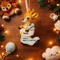Load image into Gallery viewer, A glossy resin baby deer ornament features a cute fawn character sitting inside a soft pastel blue winter boot, holding a striped candy cane, with gentle antler details, smooth painted cartoon style finish, soft holiday lighting and blurred festive background, handwritten personalization showing the baby name on the boot and the year or Baby’s First Christmas text below, designed as a mostly 2D ornament with raised 3D details on the front only.
