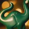 Load image into Gallery viewer, Close-up of a green dinosaur ornament with a blurred background