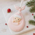 Load image into Gallery viewer, Decorative ornament of a baby in a pink basket with Christmas decorations on a white surface.