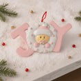 Load image into Gallery viewer, Decorative ornament shaped like the word 'JOY' with a baby face on a snowy background.