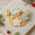 Load image into Gallery viewer, Personalized Baby First Christmas Ornament featuring a sweet newborn tucked inside a cozy woven basket with a soft blue star hat and matching blanket. This 3D front design includes raised details, textured knit pattern, and adorable teddy bear accent, creating depth and charm. Name is displayed on the hat and year on the star. A heartfelt keepsake for babyâs first holiday, nursery decor, or newborn gift. Perfect Christmas tree ornament for new parents.