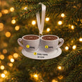 Load image into Gallery viewer, Decorative ornament with two coffee cups on a saucer against a Christmas tree background.