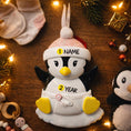 Load image into Gallery viewer, Personalized Baby Penguin First Christmas Ornament featuring a sweet penguin wearing a soft pink winter hat, sitting on a snowy base. The babyâs name is displayed on the hat and the year is placed on the belly, creating a meaningful keepsake for a newbornâs first holiday season. With bright yellow feet, soft winter details, and charming 3D design, this ornament is perfect for baby girls celebrating their very first Christmas and makes a thoughtful holiday gift for new parents.