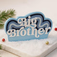 Load image into Gallery viewer, Personalized Big Brother Christmas ornament with custom name and year detail in layered blue and white design. This sibling holiday ornament features raised 3D front lettering and a lightweight flat back, perfect for Christmas tree decor.