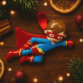 Load image into Gallery viewer, Superhero figurine on a wooden surface with Christmas decorations