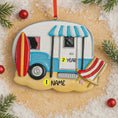 Load image into Gallery viewer, Decorative ornament shaped like a camper with a surfboard and beach chair on a sandy background.