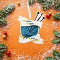 Load image into Gallery viewer, A cozy knitting yarn ornament featuring a detailed blue ball of yarn wrapped with flowing ribbon and raised knitting needles. The ornament has a sculpted 3D front with realistic yarn texture and smooth glossy finish, while the back is flat and 2D for easy hanging. Personalized with a handwritten name and year, this resin ornament is displayed in a warm festive setting with soft holiday lights, creating a heartfelt and nostalgic feel. Perfect for grandmother gifts, knitting lovers, and handmade craft themed