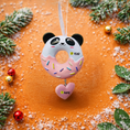 Load image into Gallery viewer, Decorative donut ornament with panda design on a snowy surface with Christmas decorations.