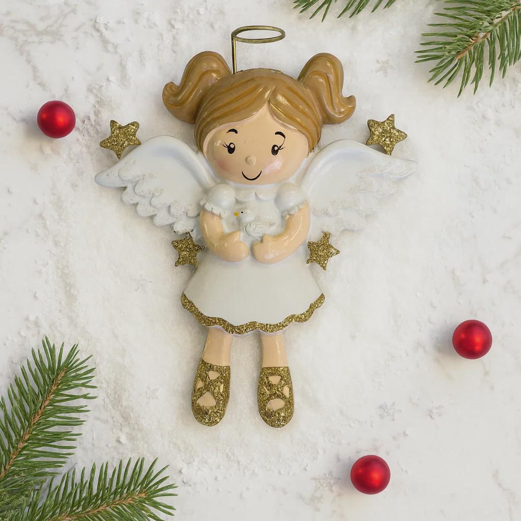Decorative angel ornament with gold hair and shoes, surrounded by Christmas decorations on a white background.