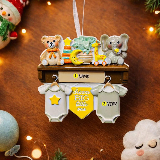 Decorative baby ornament with teddy bear, elephant, and giraffe on a wooden surface.
