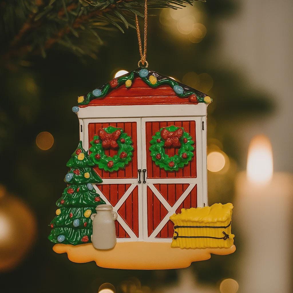 Decorative Christmas ornament shaped like a barn with wreaths, a tree, and a lantern on a blurred Christmas tree background.