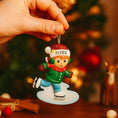 Load image into Gallery viewer, This personalized ice skating boy ornament features a cheerful winter skater wearing festive holiday clothing and gliding across an icy base. The design includes a custom name on the hat and a year displayed on the base, making it a perfect keepsake for celebrating winter memories, first Christmas moments, or a child’s love for ice skating and winter sports.


