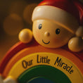 Load image into Gallery viewer, Toy figure with a rainbow and 'Our Little Miracle' text, wearing a Santa hat.
