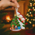 Load image into Gallery viewer, Decorative Christmas ornament with children around a tree, held by a hand with a festive background.
