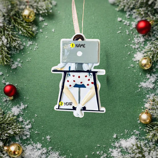 Decorative ornament with a design of a person using a laptop, surrounded by Christmas decorations on a green background.