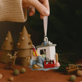 Load image into Gallery viewer, Decorative ornament of a cartoon character in an office setting held by a hand with a festive background.
