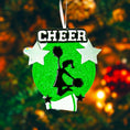 Load image into Gallery viewer, Personalized cheerleading Christmas ornament featuring a bright green glitter background with a cheer silhouette holding pom poms, bold CHEER title at the top, customizable name area on the lower banner, customizable year displayed on a star detail, and additional personalization space for school name or initials, glossy finish with raised 3D front elements and flat 2D back, white hanging ribbon, photographed on a snowy sports field themed holiday background with festive ornaments and winter greenery.
