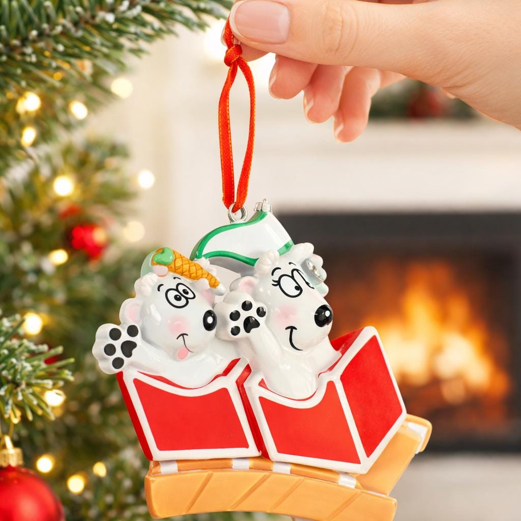Christmas ornament of two puppies in a red box held by a hand with a festive background.