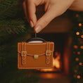 Load image into Gallery viewer, brown briefcase ornament on a green surface with Christmas decorations

