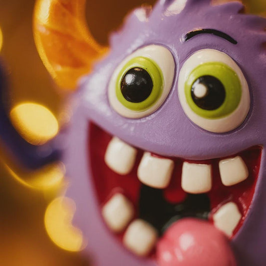 Toy monster with large eyes and a wide mouth against a blurred background