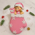 Load image into Gallery viewer, Personalized Baby Girl Christmas Ornament featuring a sweet baby in a pink stocking with raised 3D front details and textured snowflake accents. The name is added on the hat and the year on the stocking, creating a meaningful newborn keepsake. Soft pink tones, holiday elements, and dimensional design make it perfect for baby’s first Christmas, baby girl gift, and special family memory ornament for the tree.
