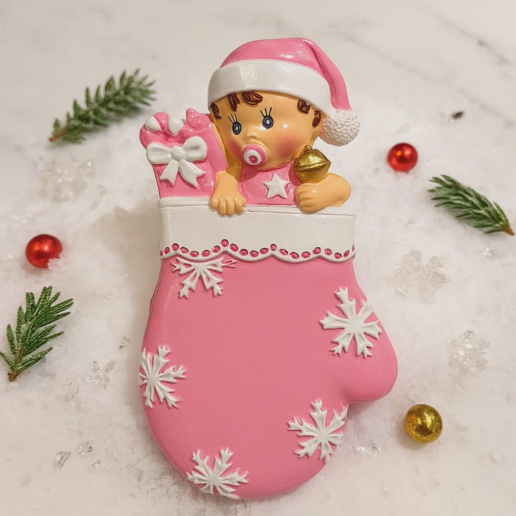 Personalized Baby Girl Christmas Ornament featuring a sweet baby in a pink stocking with raised 3D front details and textured snowflake accents. The name is added on the hat and the year on the stocking, creating a meaningful newborn keepsake. Soft pink tones, holiday elements, and dimensional design make it perfect for baby’s first Christmas, baby girl gift, and special family memory ornament for the tree.