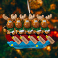 Load image into Gallery viewer, Personalized Christmas ornament with moose in a canoe, each holding a name tag, against a blurred Christmas tree background.
