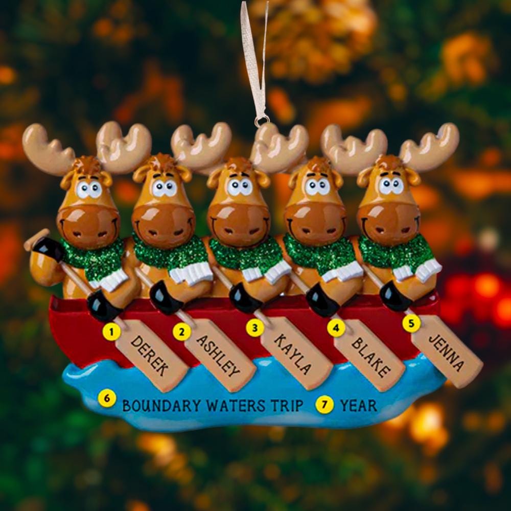 Personalized Christmas ornament with moose in a canoe, each holding a name tag, against a blurred Christmas tree background.