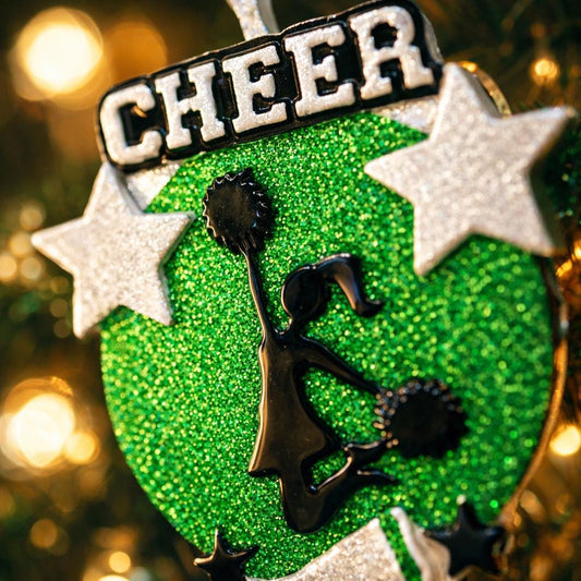 Personalized cheerleading Christmas ornament featuring a bright green glitter background with a cheer silhouette holding pom poms, bold CHEER title at the top, customizable name area on the lower banner, customizable year displayed on a star detail, and additional personalization space for school name or initials, glossy finish with raised 3D front elements and flat 2D back, white hanging ribbon, photographed on a snowy sports field themed holiday background with festive ornaments and winter greenery.