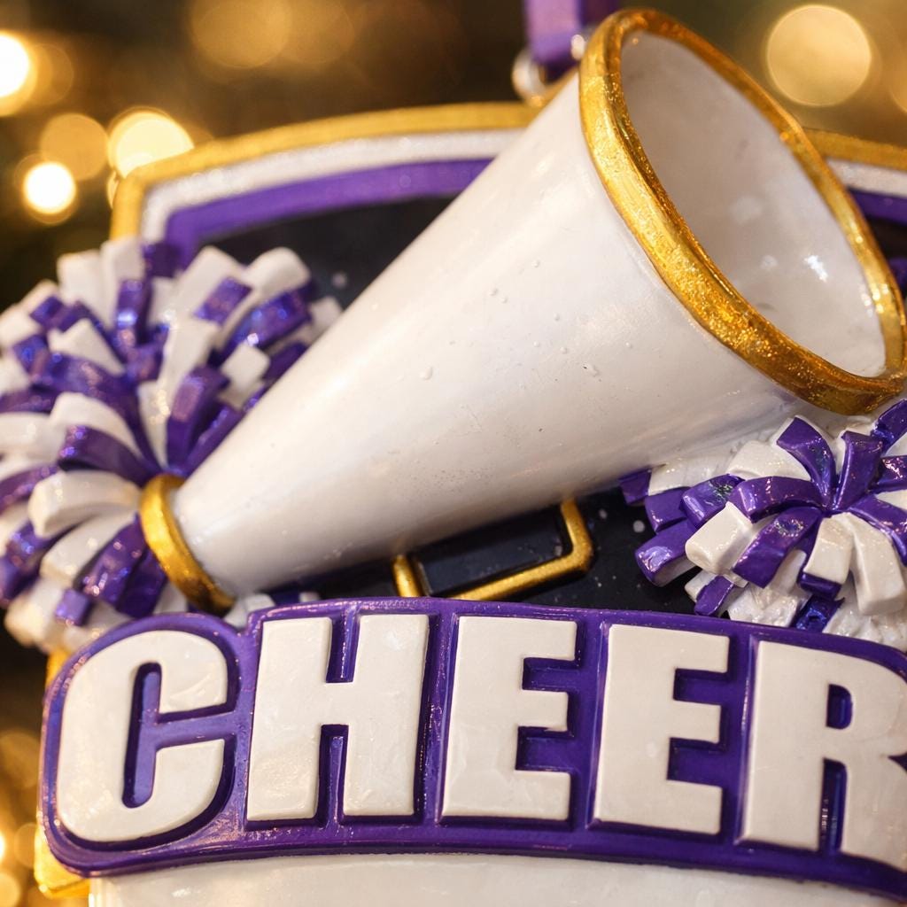 Decorative ornament with megaphone, pom-poms, and 'CHEER' letters on a blurred background