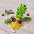 Load image into Gallery viewer, Pineapple-shaped object with sunglasses on a decorative background
