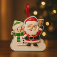 Load image into Gallery viewer, Personalized Santa and snowman ornament featuring a classic Christmas design with Santa holding a bell and a smiling snowman standing beside him. The ornament includes custom name and year personalization on the figures and base. Finished with a smooth glossy surface and detailed 3D front, it is designed for easy hanging on a Christmas tree. Perfect for festive holiday decor, family keepsakes, and seasonal gift giving.
