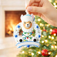 Load image into Gallery viewer, Personalized baby boy llama ornament featuring a cute smiling llama wearing a winter hat and surrounded by a festive wreath with colorful holiday lights. Soft blue and white tones create a cozy winter look. Handwritten personalization includes baby name and Baby’s First Christmas with year. Mostly 2D ornament with raised 3D details on the front only, lightweight and perfect for Christmas trees, nursery decor, and baby keepsakes.
