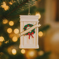 Load image into Gallery viewer, Decorative ornament of a door with a wreath on a Christmas tree with blurred lights in the background
