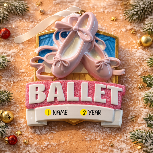 Personalized ballet Christmas ornament featuring soft pink ballet shoes with delicate ribbon details and a glittered ballet banner, customizable name area on the lower front ribbon and customizable year area beside the name, glossy finish with raised 3D front elements and flat 2D back, white hanging ribbon, displayed on a warm snowy holiday background with festive greenery ornaments and cozy Christmas decor.