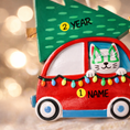 Load image into Gallery viewer, Festive cat themed Christmas ornament featuring a cheerful kitty riding in a red car with a decorated Christmas tree on top. Designed with playful holiday colors and a joyful winter atmosphere, this ornament adds a fun and cozy touch to any Christmas tree. Includes personalization options for name and year, making it a unique keepsake for cat lovers and pet themed holiday decor.

