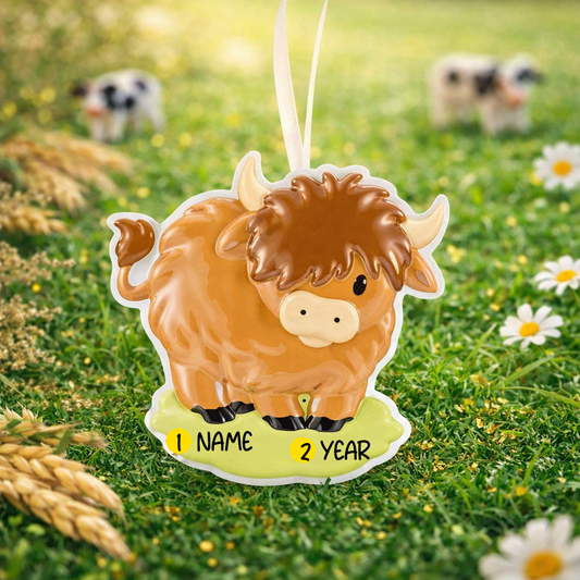 Adorable Highland cow themed Christmas ornament featuring a fluffy brown cow design with soft rounded details and a warm countryside feel. Styled in a natural green meadow setting, this ornament is designed to be personalized and brings a cozy farm inspired charm to holiday tree decor.
