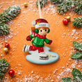 Load image into Gallery viewer, This ice skating girl ornament features a joyful winter character gliding on ice, wearing a festive red and green outfit with cozy winter details. The design highlights a playful skating pose, soft facial expression, and winter accessories that capture the magic of the holiday season. Personalized with a name on the hat and a year on the ice base, this ornament works beautifully as a Christmas tree decoration or winter keepsake gift for children and families.
