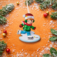 Load image into Gallery viewer, This personalized ice skating boy ornament features a cheerful winter skater wearing festive holiday clothing and gliding across an icy base. The design includes a custom name on the hat and a year displayed on the base, making it a perfect keepsake for celebrating winter memories, first Christmas moments, or a child’s love for ice skating and winter sports.

