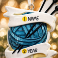 Load image into Gallery viewer, A cozy knitting yarn ornament featuring a detailed blue ball of yarn wrapped with flowing ribbon and raised knitting needles. The ornament has a sculpted 3D front with realistic yarn texture and smooth glossy finish, while the back is flat and 2D for easy hanging. Personalized with a handwritten name and year, this resin ornament is displayed in a warm festive setting with soft holiday lights, creating a heartfelt and nostalgic feel. Perfect for grandmother gifts, knitting lovers, and handmade craft themed 

