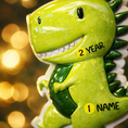 Load image into Gallery viewer, Personalized dinosaur Christmas ornament with a raised 3D front featuring a cute green dinosaur design and glossy detailed texture. The ornament has a flat 2D back for easy hanging and durability. Bright green color, playful smile, and sculpted spikes create a fun and eye catching look. Hand personalized with name and year. Perfect kids Christmas ornament, dinosaur themed holiday decor, and personalized keepsake gift.
