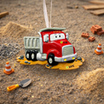 Load image into Gallery viewer, Red toy dump truck ornament on a sandy surface with construction-themed decorations.
