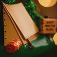 Load image into Gallery viewer, Close-up of a toy truck with a brown bed and red wheel on a green background
