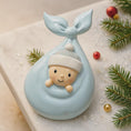 Load image into Gallery viewer, Decorative item with a baby figure inside a whale tail on a festive background.
